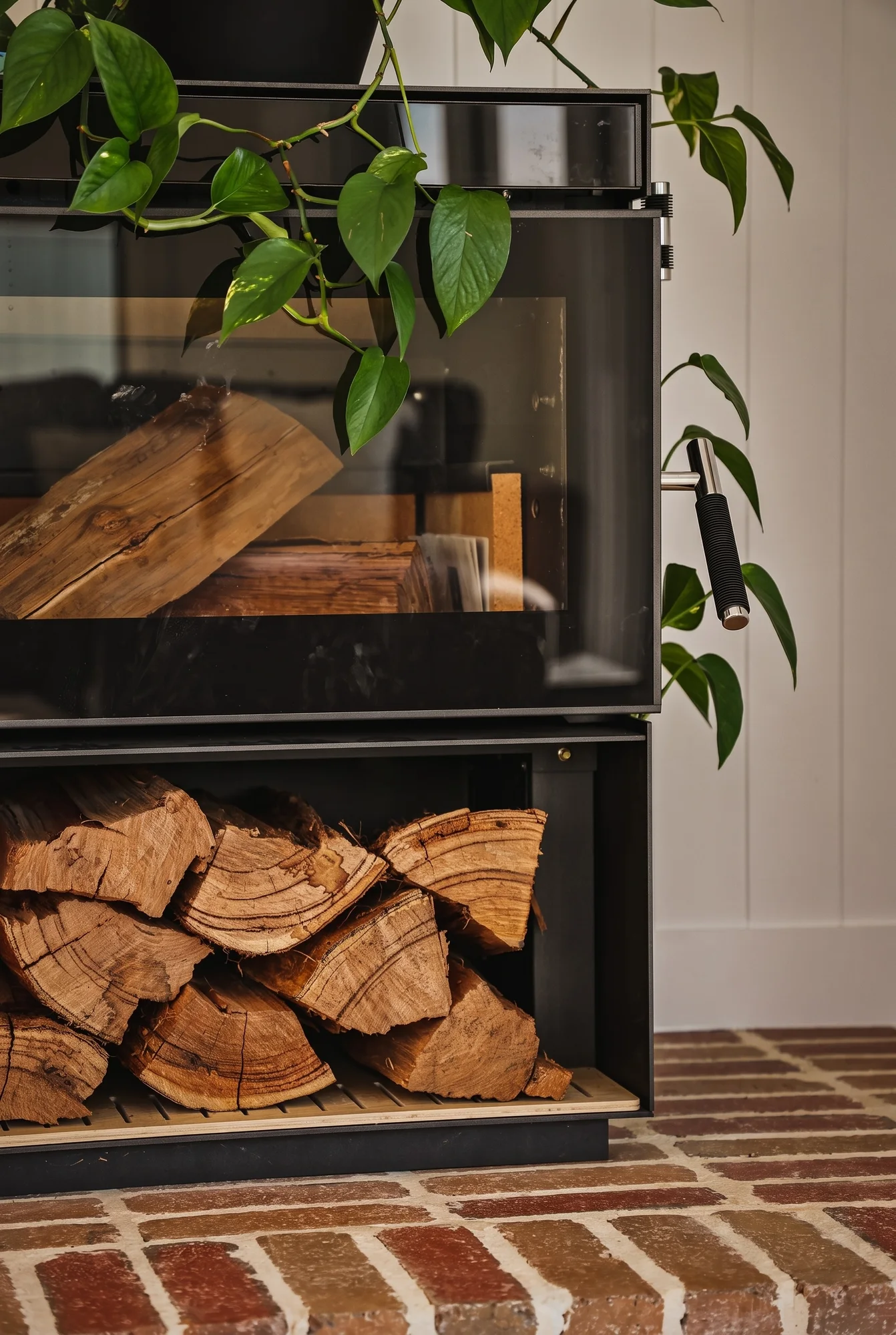Wood fire on a brick hearth with a log store below